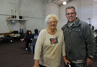 Maggie Selman of Craigsville, W.Va., stands with W.Va. Air Guard Lt. Col Yancy Short in the Summersville Baptist Church New Life Center, which operated as a shelter for the community during Hurricane Sandy. Selman was rescued by National Guard servicemembers after her power went out and snow blocked the road to her house. Short and other guard members helped return Selman to her home after hearing her storyabout being a Rosie the Riveter at the shelter.